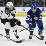 Arizona Coyotes centre Travis Boyd (72) and Toronto Maple Leafs right wing William Nylander (88) battle for the puck during first-period NHL hockey game action in Toronto, Ontario, Thursday, March 10, 2022. (Frank Gunn/The Canadian Press via AP)