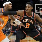 New York Knicks guard RJ Barrett (9) spins on Phoenix Suns forward Torrey Craig (0) during the first half of an NBA basketball game, Friday, March 4, 2022, in Phoenix. (AP Photo/Matt York)