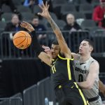 Oregon's Rivaldo Soares (11) and Colorado's Luke O'Brien (0) battle for the ball during the first half of an NCAA college basketball game in the quarterfinal round of the Pac-12 tournament Thursday, March 10, 2022, in Las Vegas. (AP Photo/John Locher)