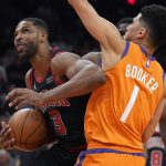 Chicago Bulls center Tristan Thompson drives on Phoenix Suns guard Devin Booker (1) during the first half of an NBA basketball game Friday, March 18, 2022, in Phoenix. (AP Photo/Rick Scuteri)