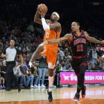 Phoenix Suns forward Torrey Craig (0) drives past Chicago Bulls forward DeMar DeRozan during the second half of an NBA basketball game Friday, March 18, 2022, in Phoenix. Phoenix won 129-102. (AP Photo/Rick Scuteri)