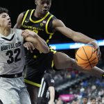 Oregon's Eric Williams Jr. (50) tires to keep the ball in bounds against Colorado's Nique Clifford (32) during the second half of an NCAA college basketball game in the quarterfinal round of the Pac-12 tournament Thursday, March 10, 2022, in Las Vegas. (AP Photo/John Locher)