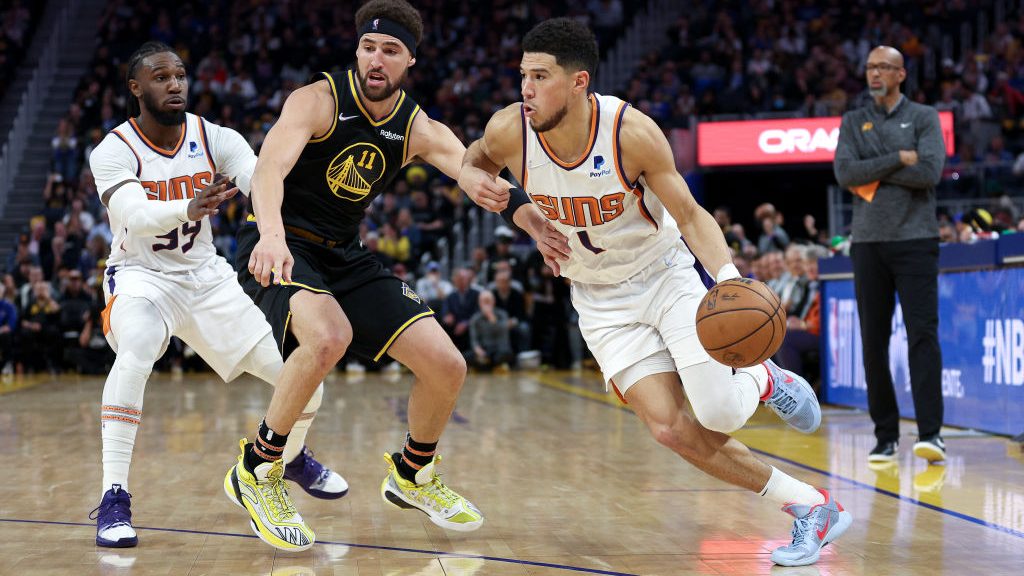 Devin Booker #1 of the Phoenix Suns is guarded by Klay Thompson #11 of the Golden State Warriors in...