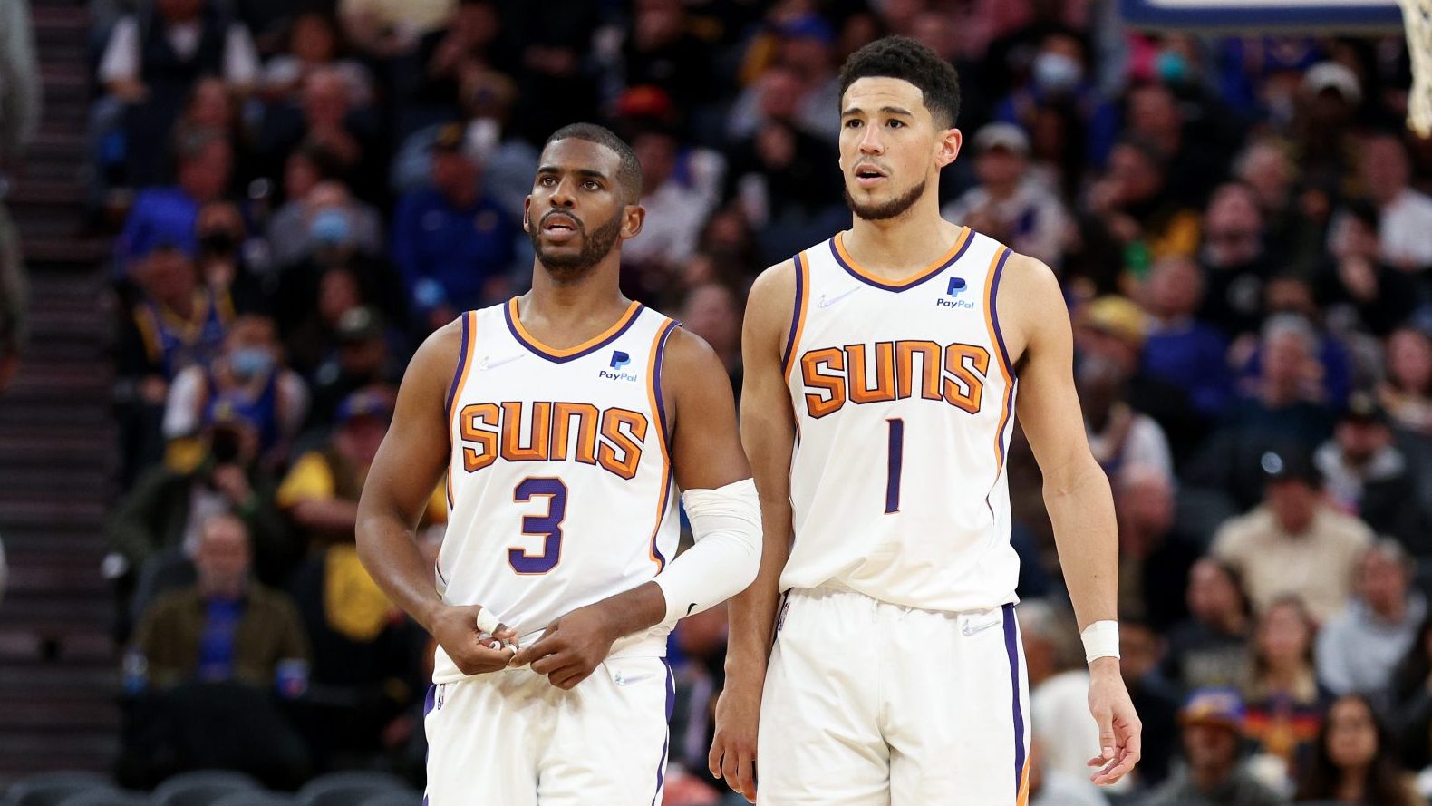 Chris Paul #3 and Devin Booker #1 of the Phoenix Suns stand on the court during their game against ...