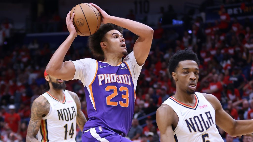 Cameron Johnson #23 of the Phoenix Suns drives against Herbert Jones #5 of the New Orleans Pelicans...