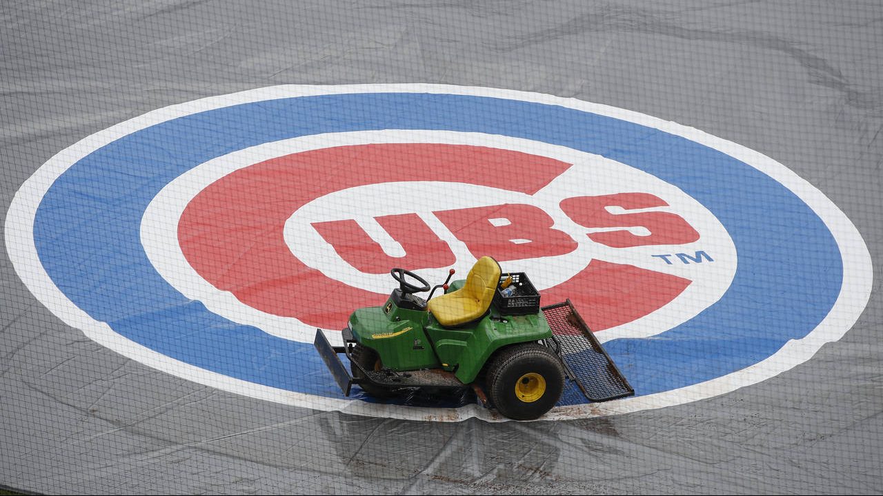 The Wrigley Field home plate is covered with the rain tarp as a baseball game between the Chicago C...