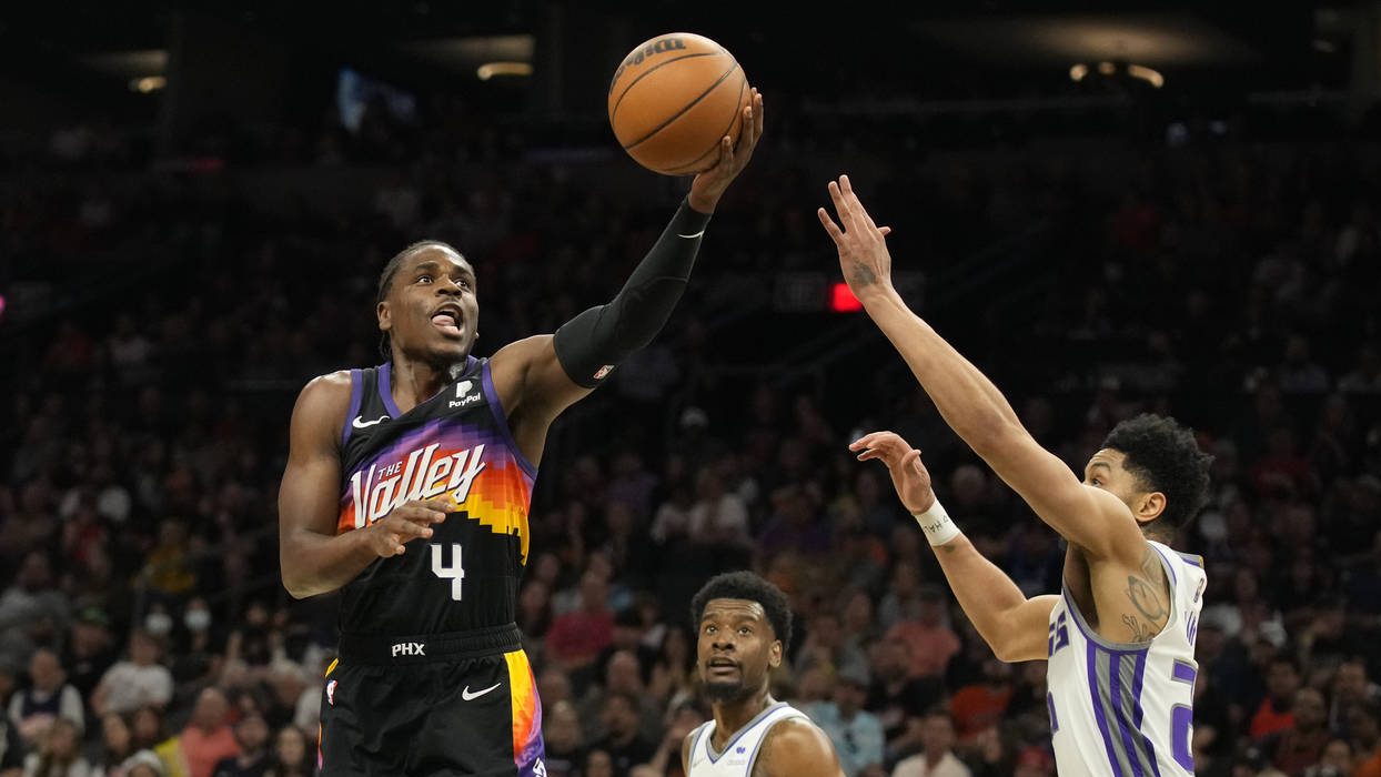 Phoenix Suns guard Aaron Holiday (4) drives between Sacramento Kings guard Josh Jackson (55) and gu...
