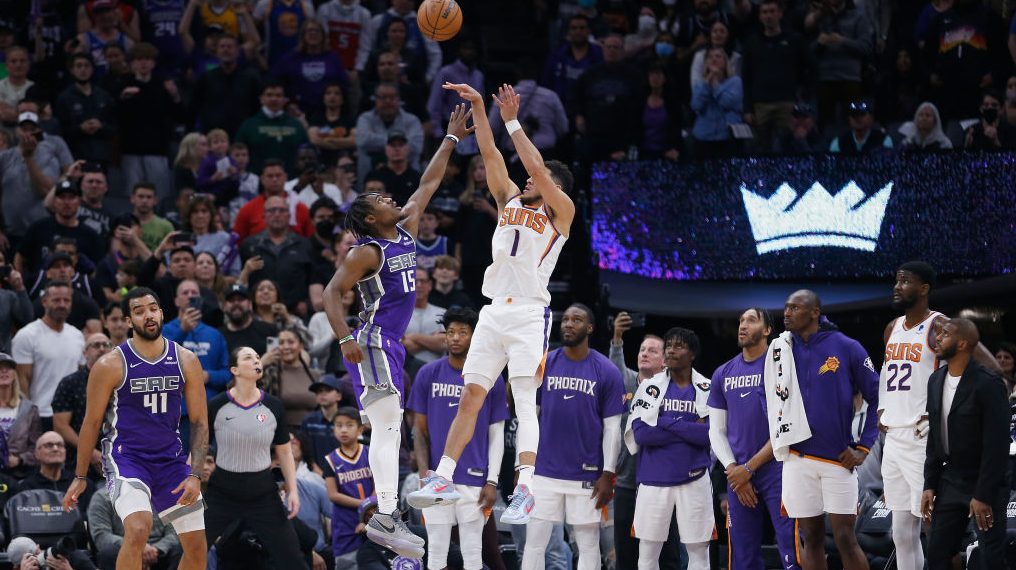 Devin Booker #1 of the Phoenix Suns makes a basket late in the fourth quarter against Davion Mitche...