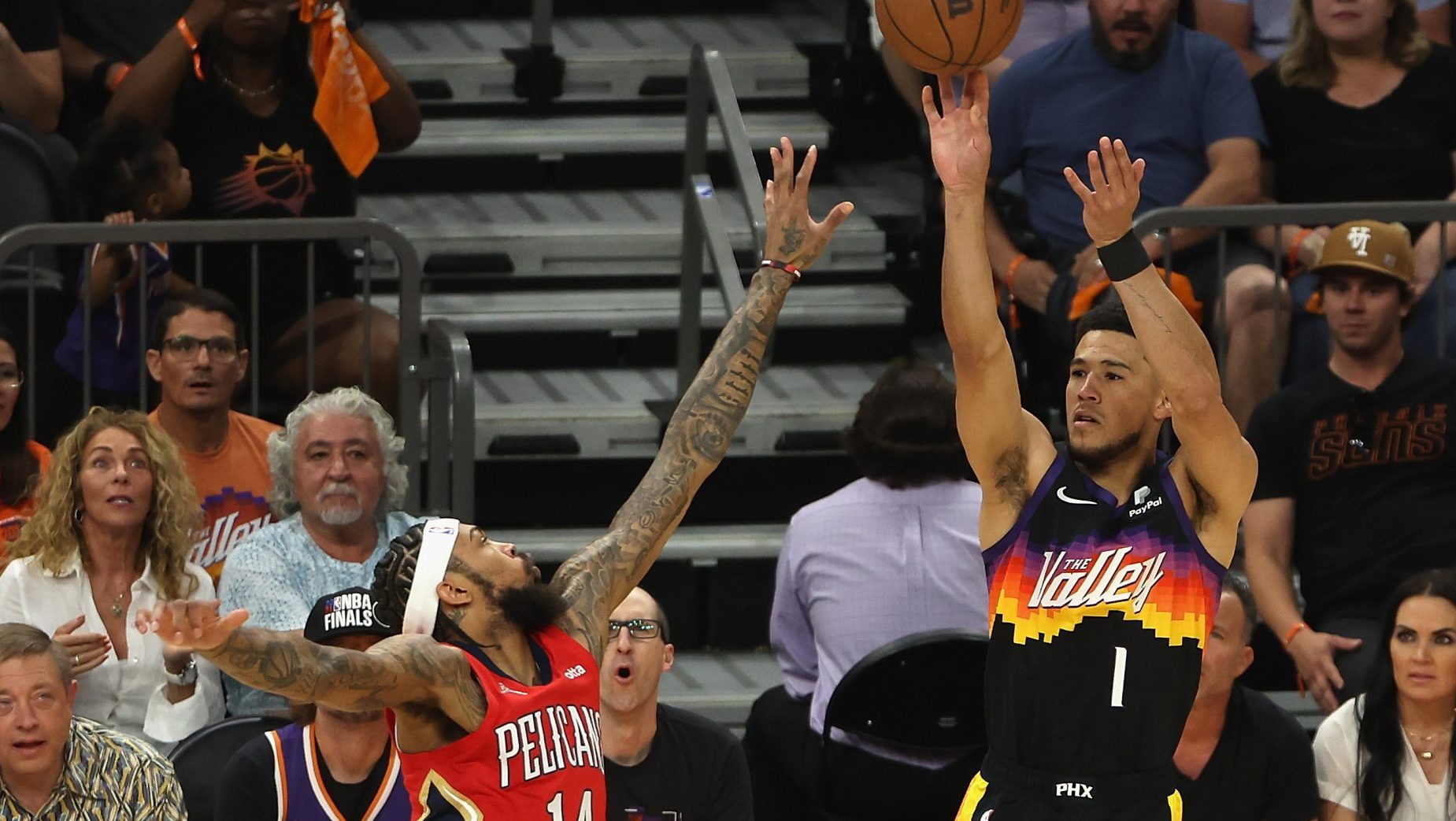 Devin Booker #1 of the Phoenix Suns attempts a shot over Brandon Ingram #14 of the New Orleans Peli...