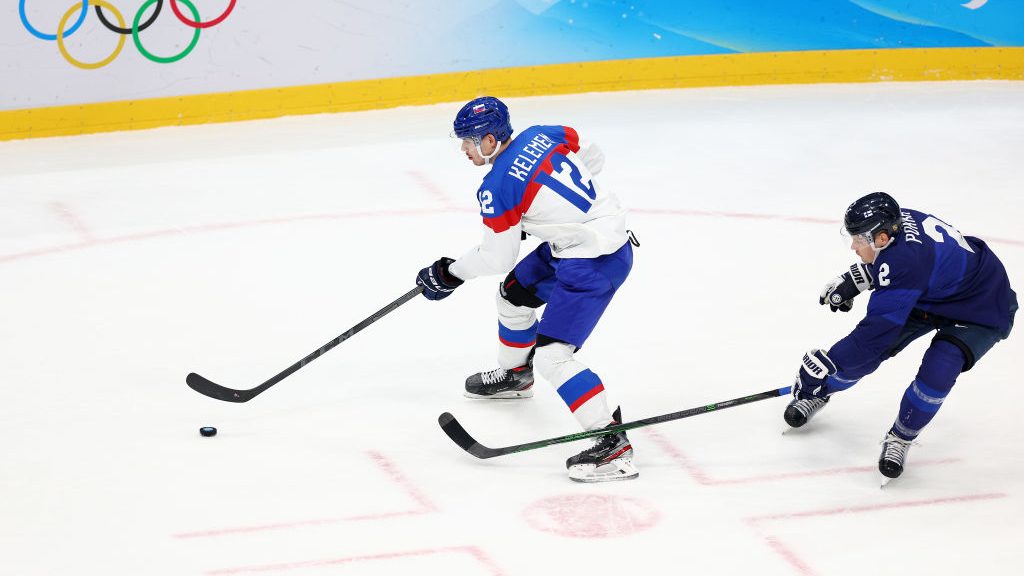 Milos Kelemen #12 of Team Slovakia skates with the puck ahead of Ville Pokka #2 of Team Finland in ...