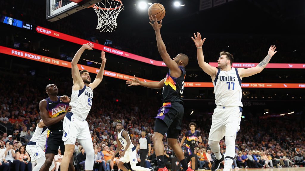 Chris Paul #3 of the Phoenix Suns puts up a shot against Maxi Kleber #42 and Luka Doncic #77 of the...