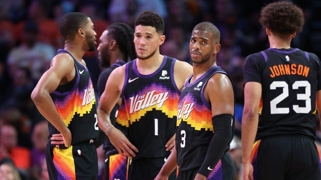 Chris Paul #3 of the Phoenix Suns stands on the court with Mikal Bridges #25, Devin Booker #1 and C...