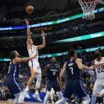 Phoenix Suns guard Devin Booker (1) shoots past Dallas Mavericks guard Jalen Brunson (13) and forward Dorian Finney-Smith (10) during the first half of Game 6 of an NBA basketball second-round playoff series, Thursday, May 12, 2022, in Dallas. (AP Photo/Tony Gutierrez)