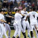 Arizona Diamondbacks' Cooper Hummel, fourth from right, celebrates with teammates after his double drovin in the winning run against the Atlanta Braves during the 10th inning of a baseball game Tuesday, May 31, 2022, in Phoenix. The Diamondbacks won 8-7. (AP Photo/Ross D. Franklin)