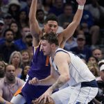 Dallas Mavericks guard Luka Doncic, front, works the ball against Phoenix Suns guard Devin Booker (1) during the first half of Game 3 of an NBA basketball second-round playoff series, Friday, May 6, 2022, in Dallas. (AP Photo/Tony Gutierrez)