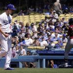 Los Angeles Dodgers starting pitcher Walker Buehler, left, celebrates as the final out is made with the bases loaded as Arizona Diamondbacks' Christian Walker runs to first during the top of the fourth inning of a baseball game Wednesday, May 18, 2022, in Los Angeles. (AP Photo/Mark J. Terrill)