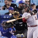 Arizona Diamondbacks' Christian Walker, right, hits a solo home run as Los Angeles Dodgers catcher Austin Barnes, left, and home plate umpire Larry Vanover watch during the second inning of a baseball game Monday, May 16, 2022, in Los Angeles. (AP Photo/Mark J. Terrill)
