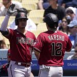 Arizona Diamondbacks' Daulton Varsho, right, is congratulated by Josh Rojas after scoring Pavin Smith grounded out during the third inning of a baseball game against the Los Angeles Dodgers Wednesday, May 18, 2022, in Los Angeles. (AP Photo/Mark J. Terrill)