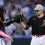 Arizona Diamondbacks relief pitcher Joe Mantiply, right, slaps gloves with catcher Jose Herrera, left, after the final out in the ninth inning of a baseball game against the Colorado Rockies, Sunday, May 8, 2022, in Phoenix. (AP Photo/Ross D. Franklin)