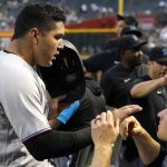 Miami Marlins' Avisail Garcia, left, gets greeted with a high-five from Joey Wendle, right, after scoring a run against the Arizona Diamondbacks during the second inning of a baseball game Monday, May 9, 2022, in Phoenix. (AP Photo/Darryl Webb)