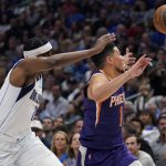 Dallas Mavericks guard Frank Ntilikina, left, and Phoenix Suns guard Devin Booker (1) reach for a loose ball during the first half of Game 3 of an NBA basketball second-round playoff series, Friday, May 6, 2022, in Dallas. (AP Photo/Tony Gutierrez)