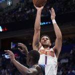 Phoenix Suns guard Devin Booker (1) shoots over Dallas Mavericks forward Dorian Finney-Smith (10) during the first half of Game 6 of an NBA basketball second-round playoff series, Thursday, May 12, 2022, in Dallas. (AP Photo/Tony Gutierrez)