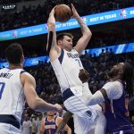 Dallas Mavericks guard Luka Doncic, center, grabs a rebound over Phoenix Suns forward Jae Crowder, right, during the first half of Game 3 of an NBA basketball second-round playoff series, Friday, May 6, 2022, in Dallas. (AP Photo/Tony Gutierrez)