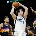 Dallas Mavericks guard Luka Doncic (77) looks to shoot against Phoenix Suns center Deandre Ayton (22) and Suns guard Devin Booker (1) during the first half of Game 5 of an NBA basketball second-round playoff series Tuesday, May 10, 2022, in Phoenix. (AP Photo/Ross D. Franklin)