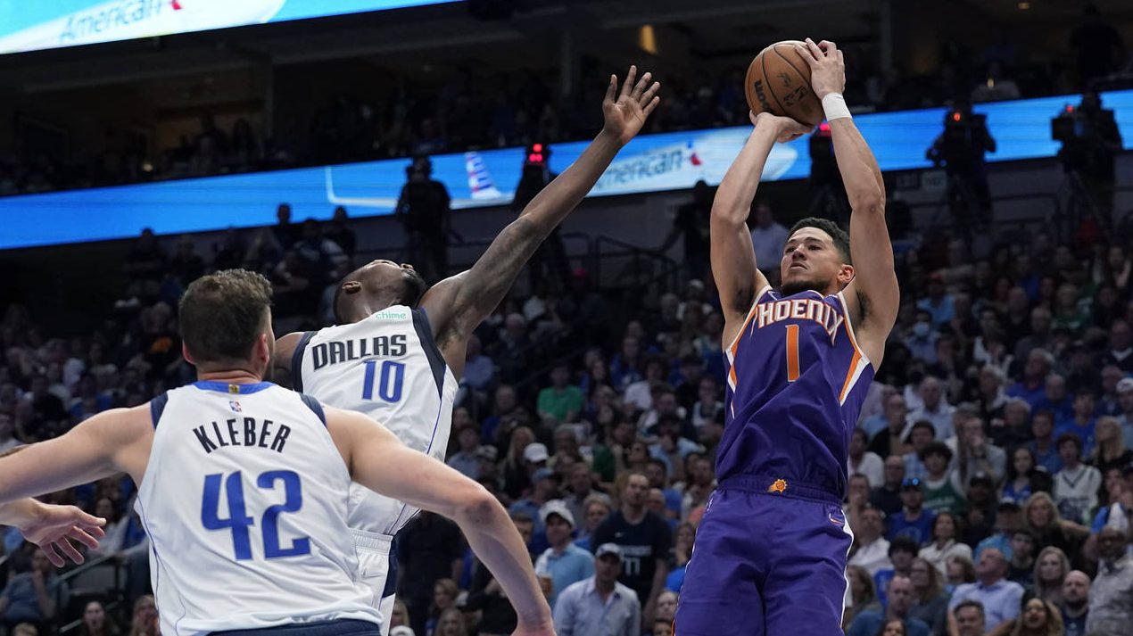 Phoenix Suns guard Devin Booker (1) shoots past Dallas Mavericks forward Dorian Finney-Smith (10) a...