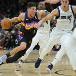 Phoenix Suns guard Devin Booker (1) drives past Dallas Mavericks center Dwight Powell (7) during the first half of Game 7 of an NBA basketball Western Conference playoff semifinal, Sunday, May 15, 2022, in Phoenix. (AP Photo/Matt York)