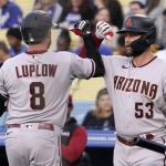 Arizona Diamondbacks' Jordan Luplow, left, is congratulated by Christian Walker after hitting a solo home run during the first inning of a baseball game against the Los Angeles Dodgers Tuesday, May 17, 2022, in Los Angeles. (AP Photo/Mark J. Terrill)