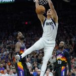 Dallas Mavericks center Dwight Powell (7) scores over Phoenix Suns center Deandre Ayton, left, and forward Jae Crowder (99) during the first half of Game 2 of an NBA basketball second round playoff series, Wednesday, May 4, 2022, in Phoenix. (AP Photo/Matt York)