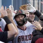 Arizona Diamondbacks' Christian Walker is congratulated by teammates in the dugout after hitting a solo home run during the second inning of a baseball game against the Los Angeles Dodgers Monday, May 16, 2022, in Los Angeles. (AP Photo/Mark J. Terrill)