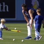 Los Angeles Dodgers pitcher Clayton Kershaw, center, pitches to his son Cooper, left, as his other son Charley watches prior to a baseball game between the Dodgers and the Arizona Diamondbacks Tuesday, May 17, 2022, in Los Angeles. (AP Photo/Mark J. Terrill)