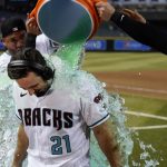 Arizona Diamondbacks' Cooper Hummel (21) is doused by Christian Walker, right, and David Peralta, back left, after Hummel's double drove in the winning run against the Atlanta Braves in the 10th inning of a baseball game Tuesday, May 31, 2022, in Phoenix. The Diamondbacks won 8-7. (AP Photo/Ross D. Franklin)