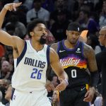 Dallas Mavericks guard Spencer Dinwiddie (26) celebrates his three-pointer as Phoenix Suns forward Torrey Craig (0) looks away during the first half of Game 7 of an NBA basketball Western Conference playoff semifinal, Sunday, May 15, 2022, in Phoenix. (AP Photo/Matt York)
