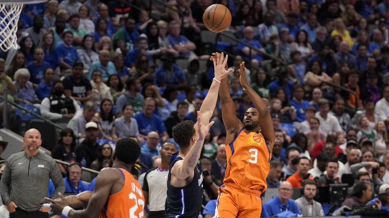 Dallas Mavericks center Dwight Powell, center, defends as Phoenix Suns guard Chris Paul (3) shoots ...