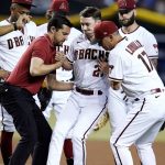 Arizona Diamondbacks starting pitcher Zach Davies, center, is helped up by Diamondbacks assistant athletic trainer Ryne Eubanks, front left, and manager Torey Lovullo (17) after being hit in the shin with a line drive by Kansas City Royals' Bobby Witt Jr. as Diamondbacks shortstop Geraldo Perdomo (2) and other teammates look on during the fourth inning of a baseball game Monday, May 23, 2022, in Phoenix. (AP Photo/Ross D. Franklin)
