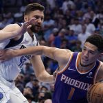 Phoenix Suns guard Devin Booker (1) drives around Dallas Mavericks forward Maxi Kleber (42) during the first half of Game 3 of an NBA basketball second-round playoff series, Friday, May 6, 2022, in Dallas. (AP Photo/Tony Gutierrez)