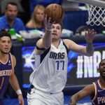 Dallas Mavericks guard Luka Doncic (77) drives to the basket between Phoenix Suns guard Devin Booker (1) and guard Chris Paul (3) during the second half of Game 3 of an NBA basketball second-round playoff series, Friday, May 6, 2022, in Dallas. (AP Photo/Tony Gutierrez)