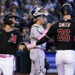 
              Arizona Diamondbacks' Alek Thomas, left, celebrates with teammate Pavin Smith (26) after scoring as Colorado Rockies catcher Dom Nunez, center, pauses at home plate in the fifth inning of a baseball game Sunday, May 8, 2022, in Phoenix. (AP Photo/Ross D. Franklin)
            