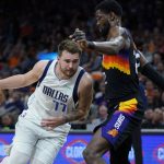 Dallas Mavericks guard Luka Doncic (77) drives around Phoenix Suns center Deandre Ayton (22) during the first half of Game 2 in the second round of the NBA Western Conference playoff series Wednesday, May 4, 2022, in Phoenix. (AP Photo/Matt York)