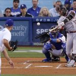 Arizona Diamondbacks' Christian Walker, right, hits a solo home run as Los Angeles Dodgers starting pitcher Tyler Anderson, left, watches along with catcher Austin Barnes during the first inning of a baseball game Tuesday, May 17, 2022, in Los Angeles. (AP Photo/Mark J. Terrill)