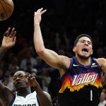 Phoenix Suns guard Devin Booker, right, gets fouled by Dallas Mavericks forward Dorian Finney-Smith, left, as Booker goes up for a shot during the second half of Game 5 of an NBA basketball second-round playoff series Tuesday, May 10, 2022, in Phoenix. The Suns won 110-80. (AP Photo/Ross D. Franklin)