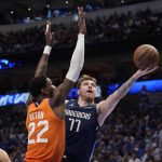 
              Phoenix Suns center Deandre Ayton (22) defends as Dallas Mavericks guard Luka Doncic (77) shoots in the second half of Game 4 of an NBA basketball second-round playoff series, Sunday, May 8, 2022, in Dallas. (AP Photo/Tony Gutierrez)
            