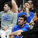 Dallas Mavericks' Luka Doncic, left, Maxi Kleber, top right, and Boban Marjanovic, middle, watch from the team bench during the second half of Game 5 of an NBA basketball second-round playoff series against the Phoenix Suns Tuesday, May 10, 2022, in Phoenix. The Suns won 110-80. (AP Photo/Ross D. Franklin)