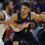 Phoenix Suns guard Devin Booker (1) works the ball around Dallas Mavericks guard Jalen Brunson (13) during the first half of Game 2 in the second round of the NBA Western Conference playoff series Wednesday, May 4, 2022, in Phoenix. (AP Photo/Matt York)