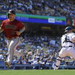Arizona Diamondbacks' Daulton Varsho, left, scores on a single by Pavin Smith as Los Angeles Dodgers catcher Will Smith takes a late throw during the seventh inning of a baseball game Wednesday, May 18, 2022, in Los Angeles. (AP Photo/Mark J. Terrill)