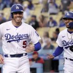 Los Angeles Dodgers' Freddie Freeman, left, and Mookie Betts laugh after they scored on a single by Trea Turner during the first inning of a baseball game against the Arizona Diamondbacks Tuesday, May 17, 2022, in Los Angeles. (AP Photo/Mark J. Terrill)