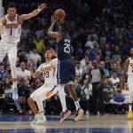 Dallas Mavericks forward Reggie Bullock (25) shoots against Phoenix Suns guard Devin Booker (1) and forward Cameron Johnson (23) during the first half of Game 6 of an NBA basketball second-round playoff series, Thursday, May 12, 2022, in Dallas. (AP Photo/Tony Gutierrez)